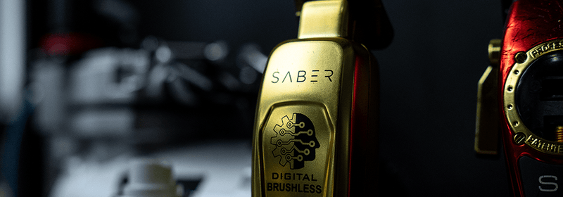 Close-up of a gold Saber hair clipper, highlighting premium grooming tools used at Montana Fades in Oakville, Ontario.