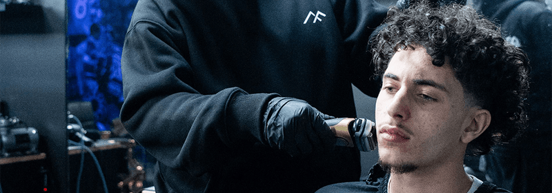 Barber at Montana Fades in Oakville, Ontario using clippers to create a clean fade haircut on a male client, highlighting barber vs. salon fade expertise.