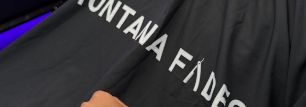 Black barber cape with ‘Montana Fades’ logo draped over a chair, showcasing branded grooming at Oakville, Ontario’s premier mobile and in-shop barbershop.”